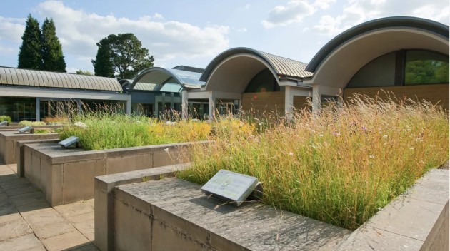 Curved roof of the Millennikum Seed Bank at Wakehurst, with planters of grasses and plants in the foregound by Jim Holden copyright RGB Kew