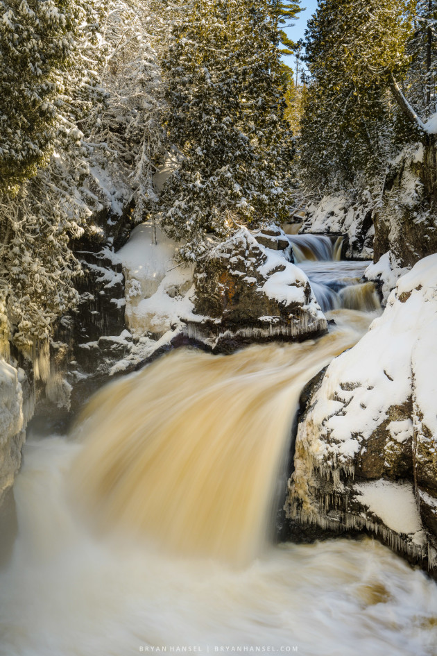 A waterfall surrounded by snow.