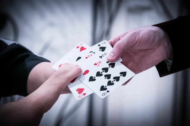 Mahdi The Magician holding red and black cards with another hand holding the other side
